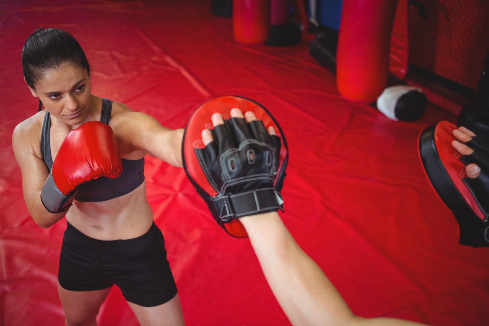 An overhead view of a student working focus-mitt combinations on the mat.